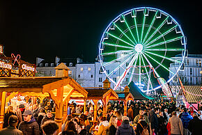 Vue nocturne du marché de noël à Poitiers avec la grande roue en fond