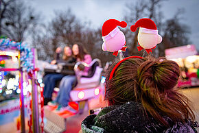 Jeune fille de dos avec un serre-tête de noël, devant un manège