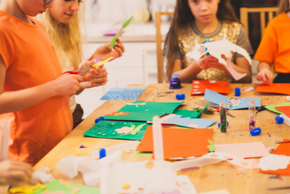 Des enfants découpent du papier pour créer des arbres.